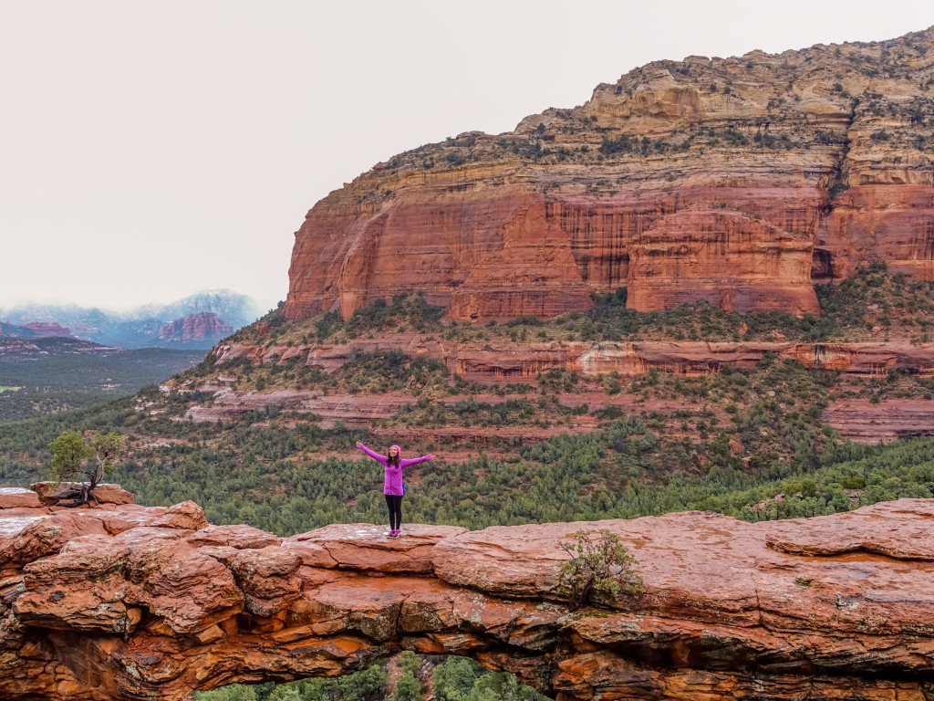 Blogger Nihan standing in Devil's bridge in Sedona, Arizona, arms wide open, connecting with nature.